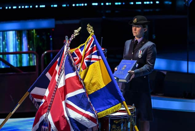 The book of remembrance is carried by Flt Lt Laura Foster