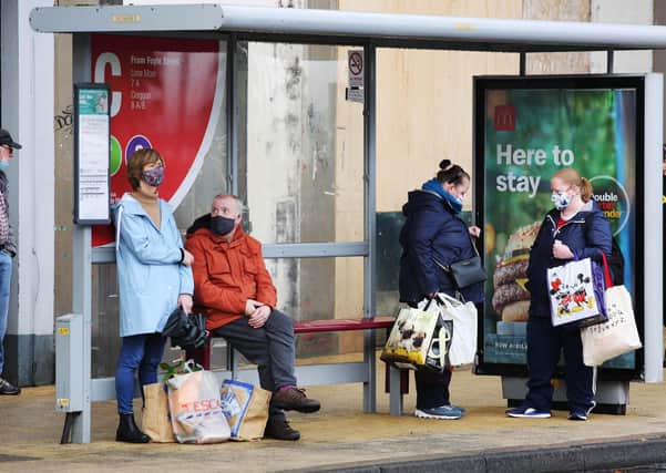 KEEPING EVERYONE SAFE.... Derry people with their masks on waiting for the bus in Foyle Street.  Picture by Lorcan Doherty / PressEye