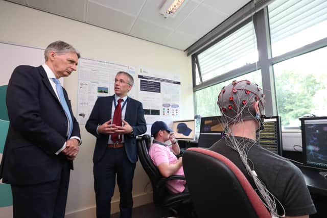 Chancellor of the Exchequer Philip Hammond (left) looks at student Carl McCready wearing a brain-computer interface, during his visit to the Magee campus of Ulster University in Derry-Londonderry. PRESS ASSOCIATION Photo. Picture date: Wednesday July 25, 2018. See PA story ULSTER Chancellor. Photo credit Former British Chancellor of the Exchequer Philip Hammond (left) looks at student Carl McCready wearing a brain-computer interface, during a visit to the Magee in 2018.should read: Niall Carson/PA Wire