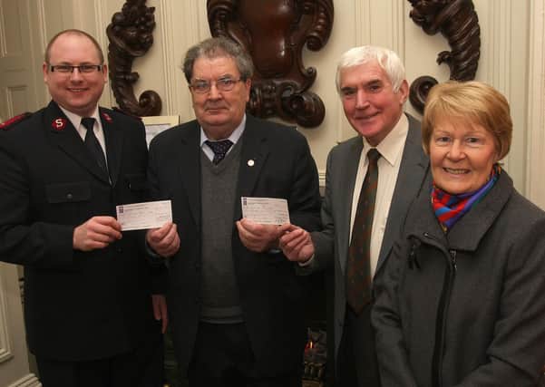 Former SDLP leader John Hume, handing over cheques, each totalling £6,000 to Lt. Dominic Eaton, with the Salvation Army and Colm McNicholl, with SVP.  The money, from the Nobel Peace Prize, was issued by the Hume Trust at their 10th annual general meeting held in the Beechill Hotel. Included is Pat Hume.  INLS 0411-534MT.