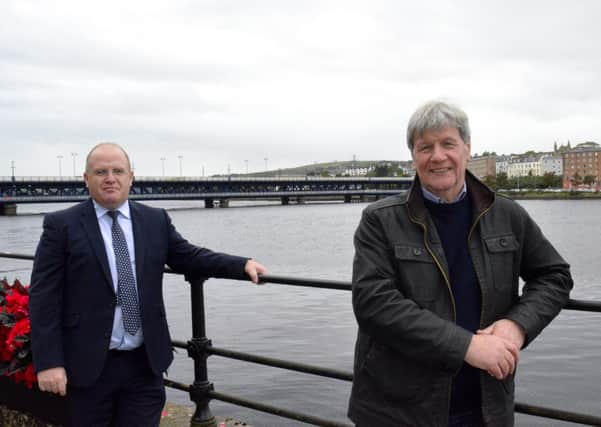 Translink's John Glass and Joe Mahon with the Craigavon Bridge in the background.