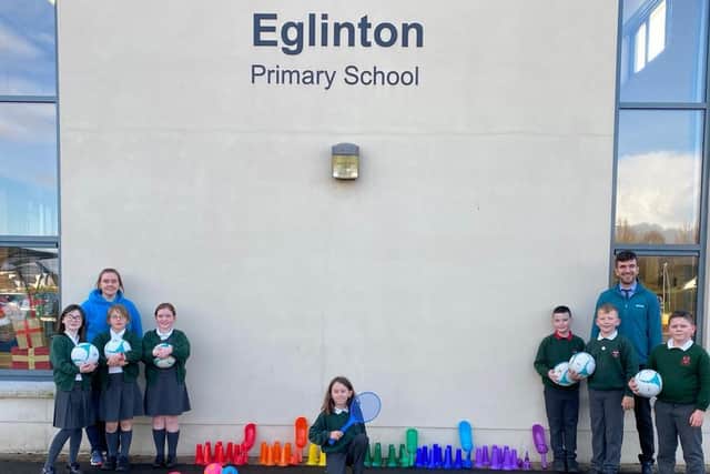Teaching staff Cahir Martin and Katie Logue, pictured with pupils from Eglinton Primary School, who recently received a donation of sporting equipment from Faughanvale GAA.