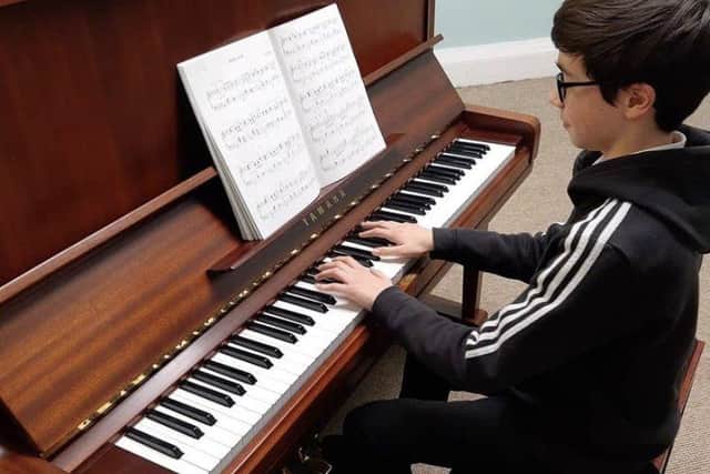One of the school's students playing the piano, Jack McGinn.