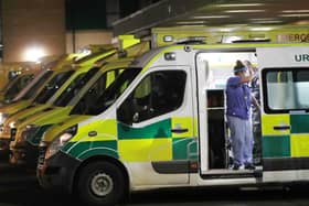 A nurse at Antrim Area Hospital waves to a patient who was waiting to be admitted in one of the rows of ambulances in the car park on Tuesday evening. (Photo: Pacemaker/Stephen Davison)