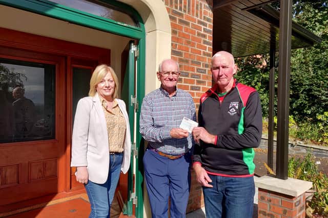 Ciaran Burke, the last surviving Trustee of the 1944 Waterside Gaelic Park Fund, presents the proceeds of the fund to Doire Trasna Chairman, Thomas McNaught and Doire Trasna Club Secretary, Anne McNaught.