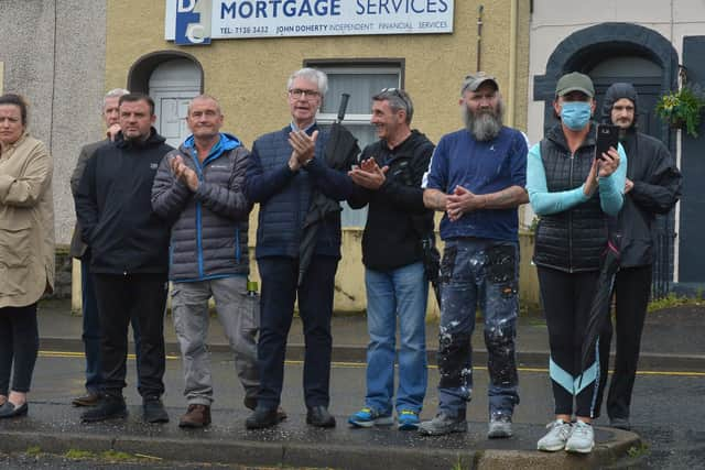 Local people clap as the funeral cortege passes towards the City Cemetery. DER2032GS –  054