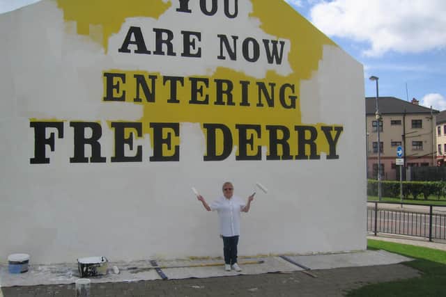 Arlene Wege pictured in years gone by painting Free Derry Corner.