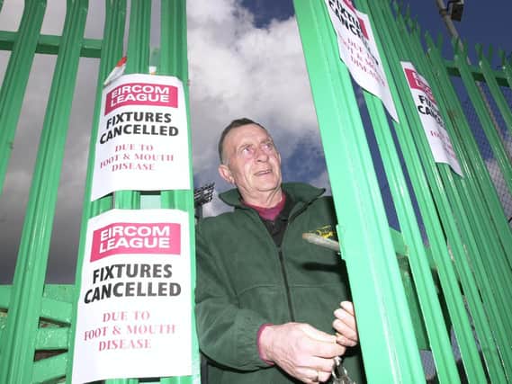 LOCKED OUT  . . . Derry City groundsman Colm Curran locks the gates of  the Brandywell Stadium following the cancellation of City’s home fixture against UCD due to the foot & mouth outbreak