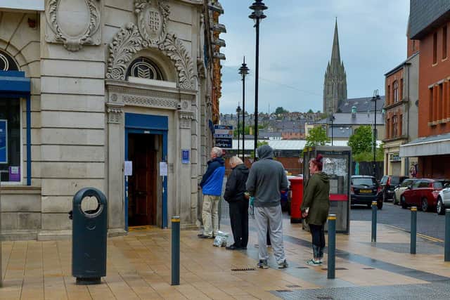People queue outside the Bank of Ireland, on Strand Road, when businesses reopened in the city centre back in June 2020. DER2420GS – 024