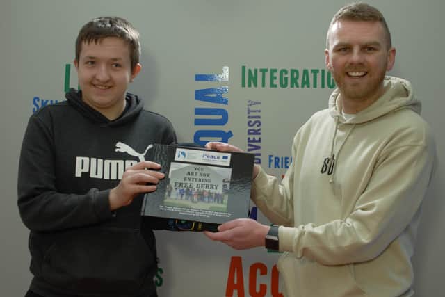 Gavin Melly and Participant Jamie Seaton presenting 32 photo book and hoodie for completing the project