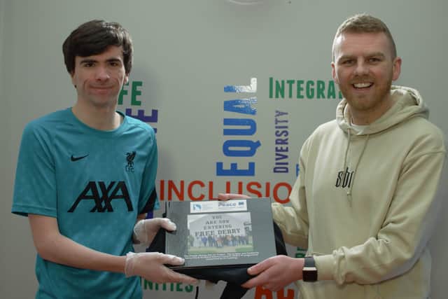 Gavin Melly and Participant Jared McKenna presenting 32 photo book and hoodie for completing the project