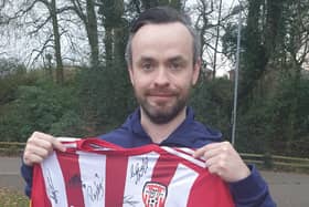 Supporter Colin O’Kane receives a signed Derry City jersey for a raffle he had organised.