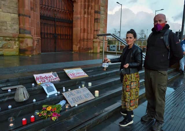 Sara Greavu and Deaglán " Mochán place a lighted candle on the Guildhall steps on Saturday evening last in remembrance of Sarah Evarard.  DER2110GS – 114