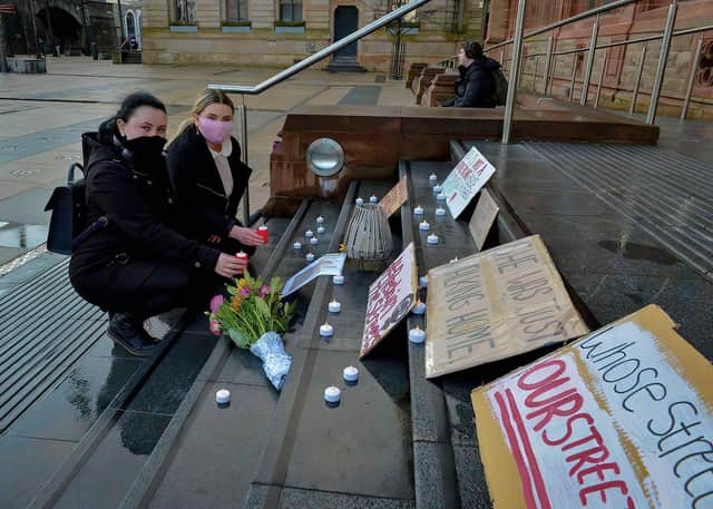 Sisters Andrea and Micaela McGillian place lighted candles on the Guildhall steps on Saturday evening last in remembrance of Sarah Everard. DER2110GS – 109