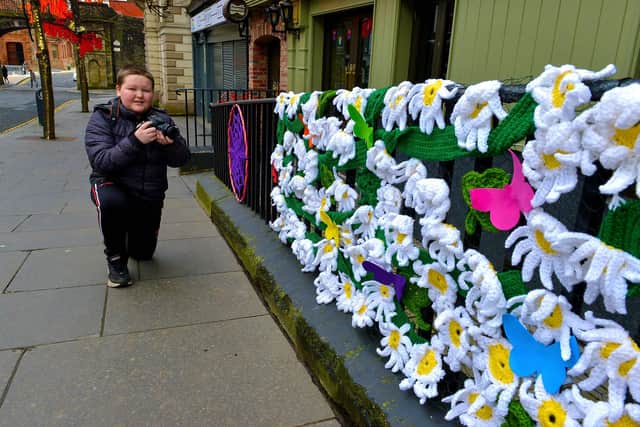 Young photographer Christopher Gillen, aged 11, photographs some of the crocheted artwork on Shipquay Street celebrating St Patrick’s Day.Photo: George Sweeney  DER2110GS – 001