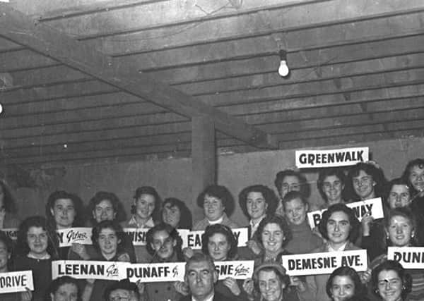 The street names of Creggan held up by fundraising residents at a Fun Fair  in Creggan  in December 1955.