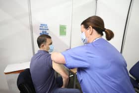 Gary Davidson (left), 55, from Lisbane in Co Down, is the first to receive the AstraZeneca vaccine from Nurse Susan McComisky at the newly opened Covid-19 vaccination centre in the SSE Arena, Belfast on Monday.