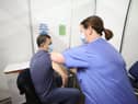 Gary Davidson (left), 55, from Lisbane in Co Down, is the first to receive the AstraZeneca vaccine from Nurse Susan McComisky at the newly opened Covid-19 vaccination centre in the SSE Arena, Belfast on Monday.