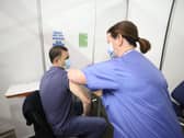 Gary Davidson (left), 55, from Lisbane in Co Down, is the first to receive the AstraZeneca vaccine from Nurse Susan McComisky at the newly opened Covid-19 vaccination centre in the SSE Arena, Belfast on Monday.