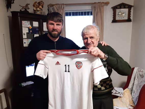 Derry City Technical Director, Paddy McCourt presents Junior Armour with a special Derry City shirt at his home in Buncrana.