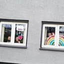 Clodagh, Aobheann and Shea O'Mora with the rainbows of hope they created for their Creggan home