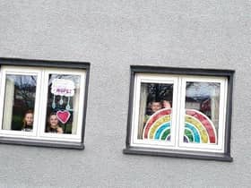 Clodagh, Aobheann and Shea O'Mora with the rainbows of hope they created for their Creggan home