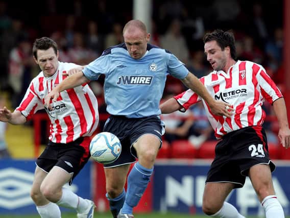 Shelbourne striker, Glen Crowe is put under pressure by Derry City's Barry Molloy and Darren Kelly.