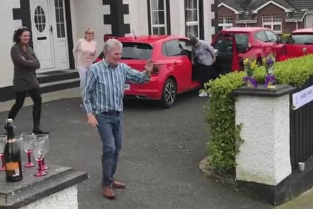 Donal Bradley waves to neighbours as he arrives home.