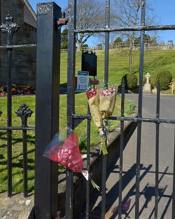 Flowers placed at the endurance to the City Cemetery which remains closed to the public. DER1720GS - 008
