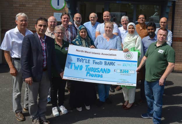 2019 - Dr Zahid front left with other members of the North West Islamic Association pictured after last year’s Ramadan fast challenge presenting the proceeds to James McMenamin, on the right, manager of the Foyle Foodbank. DER2619GS-055