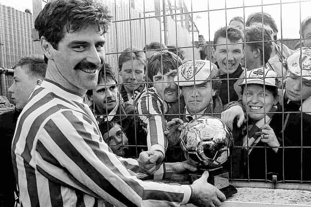 Derry City legend, Felix Healy parades the Premier Division trophy at Brandywell after defeating Cobh to clinch the title.
