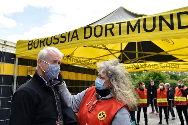 A TV crew member has his temperature checked before entering the stadium for the German Bundesliga soccer match between Borussia Dortmund and Schalke 04 in Dortmund