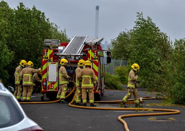 Firefighters on wasteland at Pennyburn Industrial Estate near the scene where tyres were set on alight on Saturday afternoon. The smoke from the fire caused traffic disruption on the Racecourse Road and Buncrana Road.  DER2120GS - 015