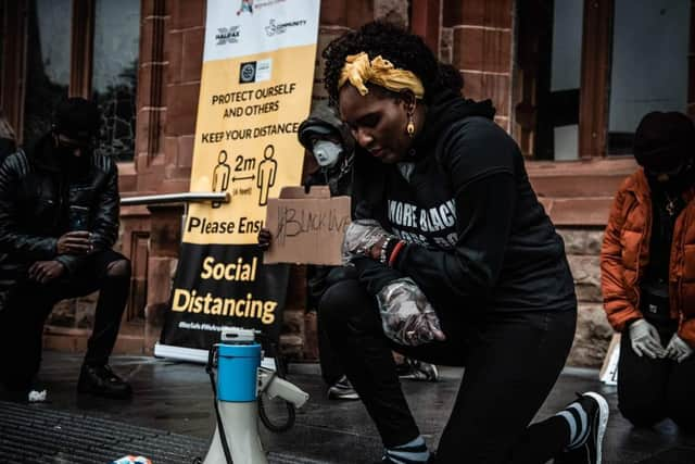 Lilian Seenoi-Barr and other speakers take the knee at the rally in Derry.