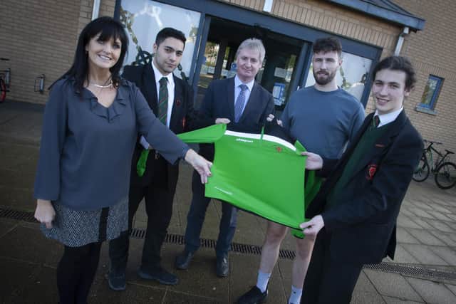 Iron Man Danny Quigley pictured receiving a school sports shirt in honour of his recent feat of ten marathons in ten days by, from left, Mrs. Margaret Ross, teacher, Abdullah Khello, Head Boy, Mr. Paul Kealey, Vice Principal and Dannyâ€TMs younger brother Colm Quigley at the school on Thursday morning.