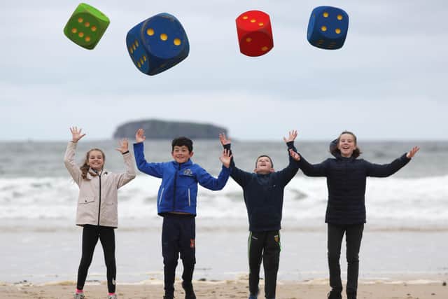 MATHSTASTIC FUN - Kaitlin McDaid, John Doherty, Dean Doherty, Ava McGonagle, who are pupils of Craigtown National School, Carndonagh, Inishowen, enjoying some fun (using dice to generate random numbers, used in equations) for Maths Week 2021 on Five Fingers Strand, near Malin Head, County Donegal.  Over 400,000 young people and the public took part in Maths Week 2021 focused on driving home the benefits of maths and all the opportunities it brings for individuals, society and the economy. www.mathsweek.ie  Picture by Lorcan Doherty / NO REPRO FEE / FREE TO USE