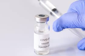 Doctor withdrawing medication from Coronavirus vaccine tube