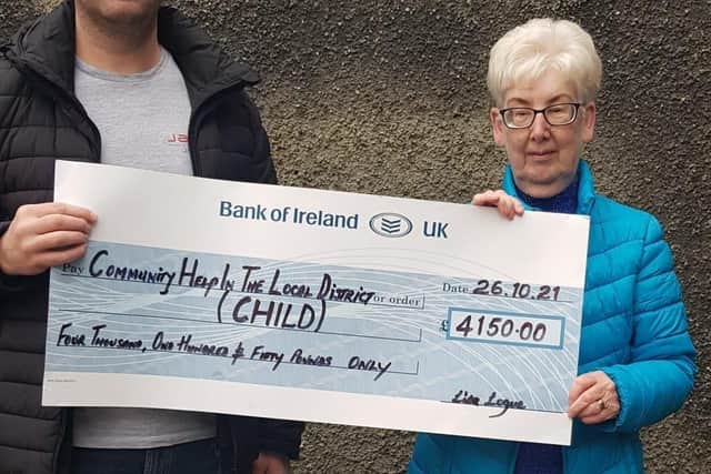 Odhran Logue presenting the cheque worth £4190.00 to Rita Wilson from CHILD