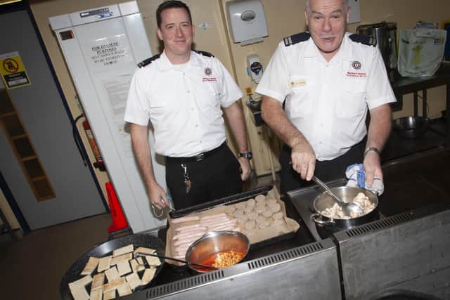 John Jennings pictured on the morning of his retirement cooking breakfast for others in the office at Crescent Link Fire Station. On left is his son Noel. (Photos: Jim McCafferty Photography)