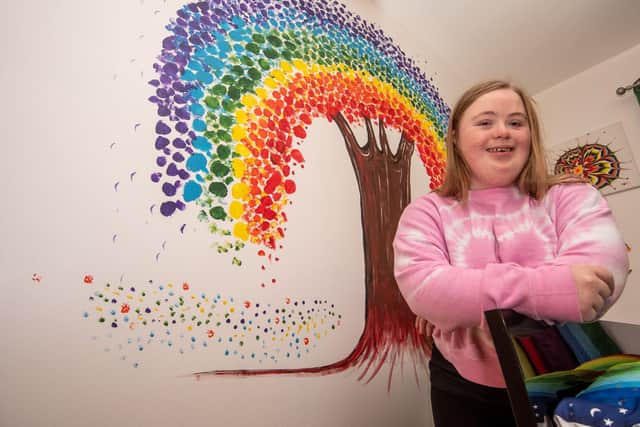 Tori pictured with some of her artwork.