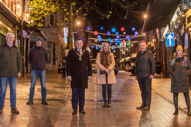 The Mayor Alderman Graham Warke pictured in Waterloo Street with the new overhead lighting installation which has been switched on. Included are from left, William McGuinness, Peadar O'Donnellâ€TMs,  Barry Davis, Echo Echo, Andrea Campbell, Derry City Strabane District Council Festival and Events Officer, Jim Roddy CEO City Centre Initiative and Stephanie English, Checkpoint Charlie. Picture Martin McKeown. 30.11.21