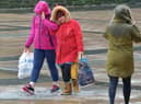 STORM BRENDAN JANUARY 2020: People walking across Guildhall Square after torrential rain and high winds brought by Storm Brendan. There are similar warnings in place for Storm Barra today. DER0220GS – 007