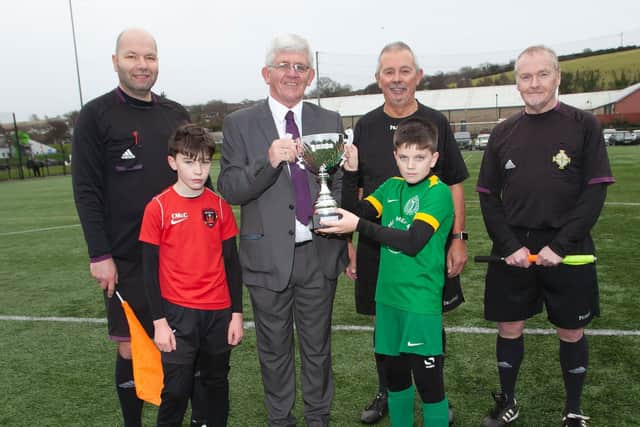 Mr. Liam Curran presents the Willie Curran Memorial Cup to Foyle Harps captain Rory McCauley at the Vale Centre on Sunday. Included at front is Conor McCauley, captain, Phoenix, and at back, Gary Boyd, Charlie Kelpie, referee and John Crossan. (Photos: Jim McCafferty Photography)