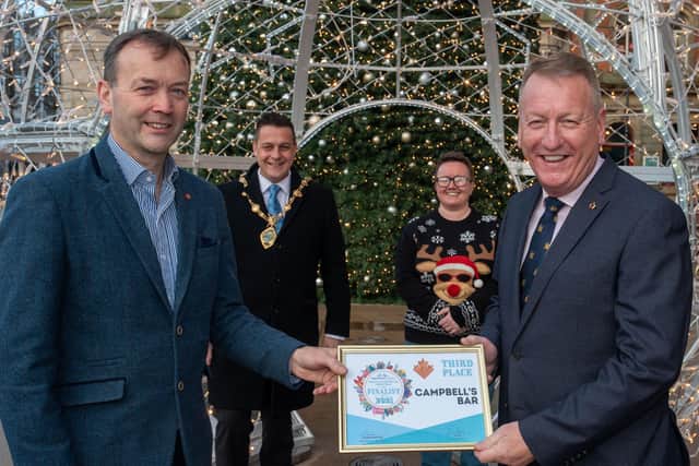 Jim Roddy accepts third place in the City Centre Initiative Twelve Windows of Christmas competition on behalf of Campbell's Bar from sponsor Fergal Rafferty, Foyleside.  Included are the Mayor Alderman Graham Warke and Lorraine Allen, Project Manager at City Centre Initiative. Picture Martin McKeown. 13.12.21
