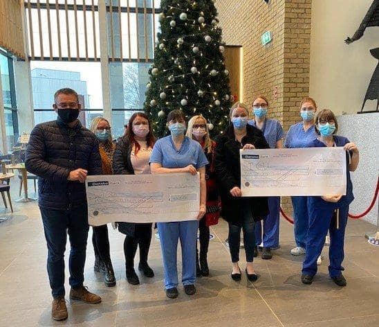 The family of the late Bobby Mullan presents a donation to staff.