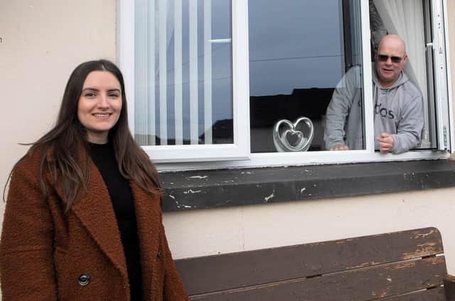 Housing Executive patch manager Nicole Nicell with tenant Anthony Canning beside one of the new windows fitted at his home in Rinmore Drive, Creggan Estate.