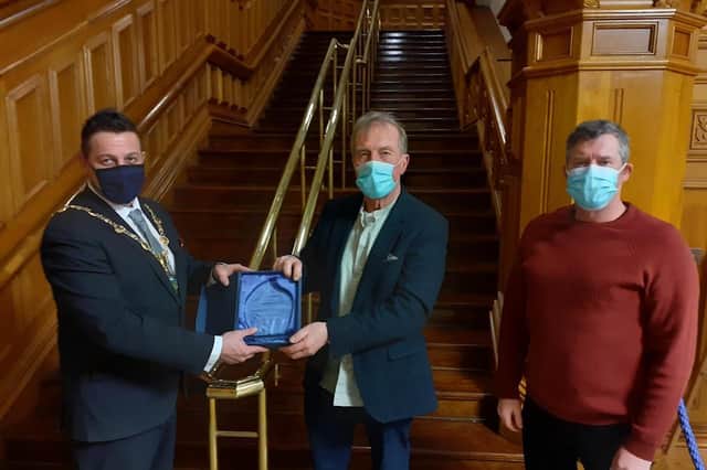 Mayor of Derry City and Strabane District Council, Alderman Graham Warke, presents a gift to Foyle Paddlers Canoe Club's Aidan Mc Kinney, club founder, and Enda Cummins, Senior Coaching Officer, at a Mayor's reception in recognition of the club's 40th anniversary.