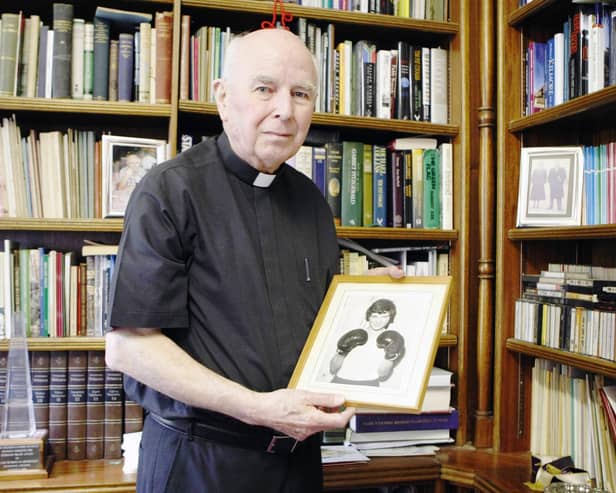 Bishop Edward Daly holds a picture of Jackie Duddy in the study of his home in Derry.