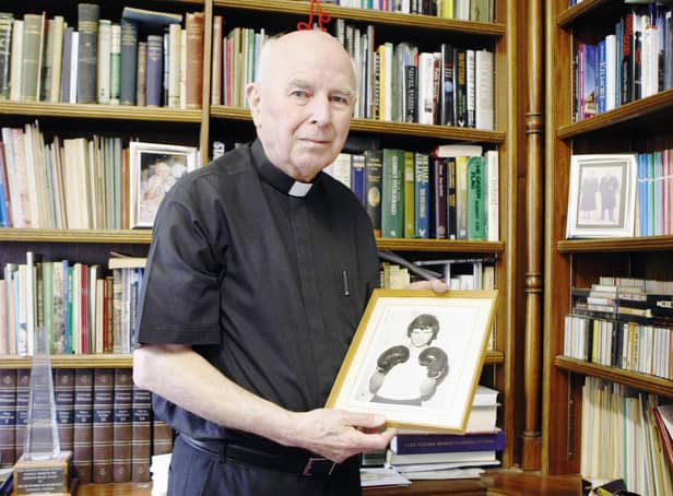 Bishop Edward Daly holds a picture of Jackie Duddy in the study of his home in Derry.