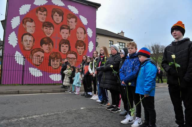 Relatives pass the mural on Westland Street depicting those killed Bloody Sunday. Photo: George Sweeney, DER2205GS – 015